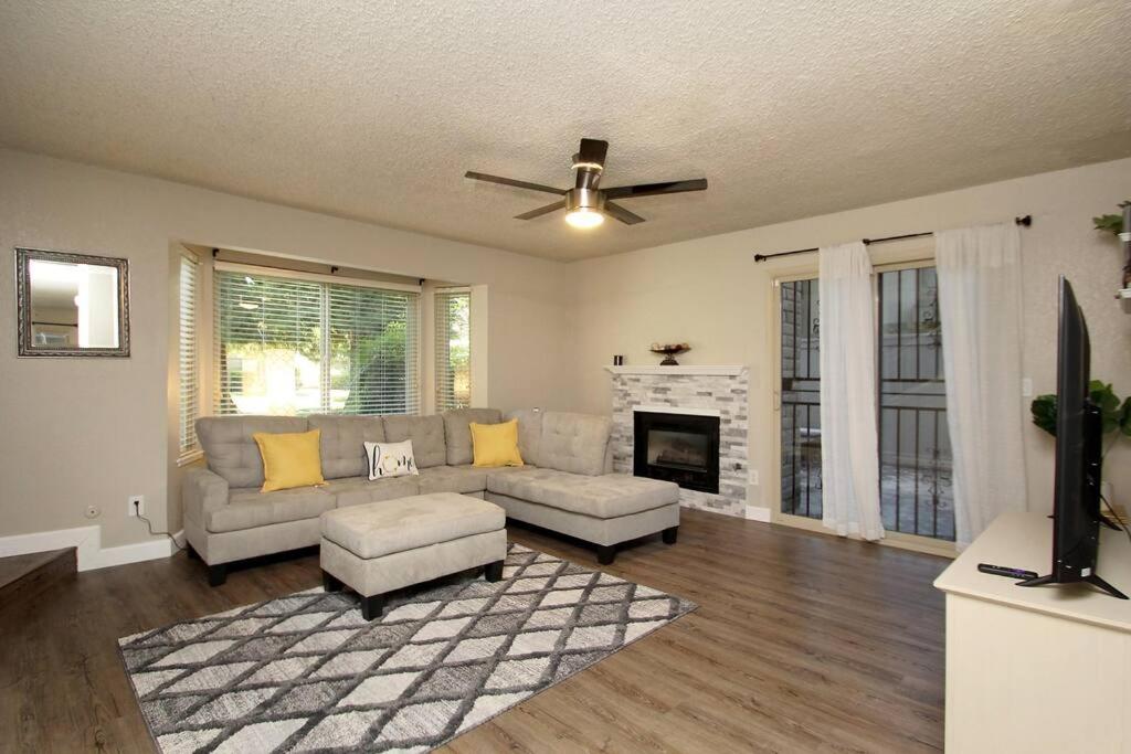 a living room with a couch and a fireplace at Townhouse Suite by FSU SaveMartCenter in Fresno
