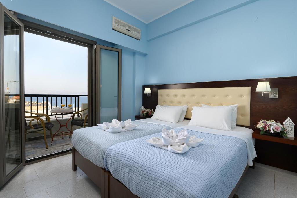 a bedroom with two beds with white flowers on them at Avra in Agia Galini