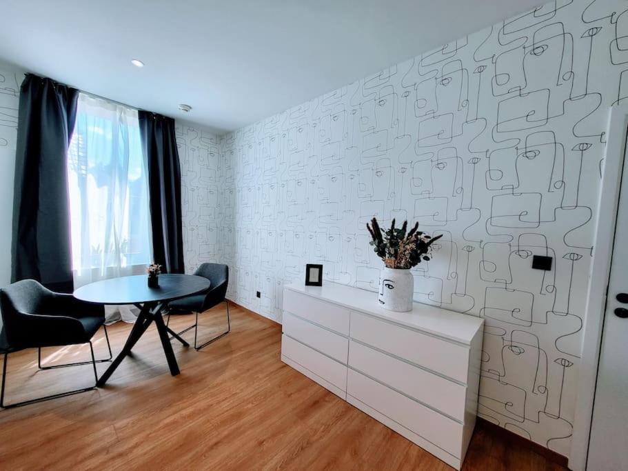 Cette chambre dispose d'une table et d'un mur blanc. dans l'établissement Black&White Studio, à Mons