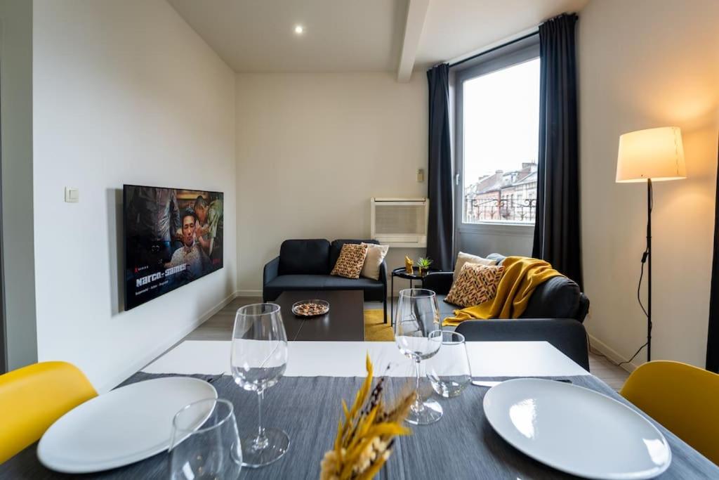 ein Wohnzimmer mit einem Tisch und Weingläsern in der Unterkunft Yellow Two in Mons