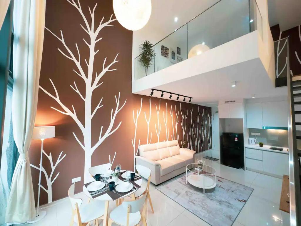 uma sala de estar com um mural de árvore na parede em EkoCheras Cozy Suite by GUESTONIC em Kuala Lumpur