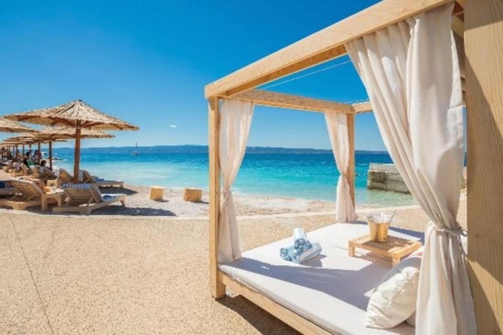 a bed on the beach with the ocean in the background at DELUX 2 bedrooms Apartment near SPLIT - GOGA in Žrnovnica