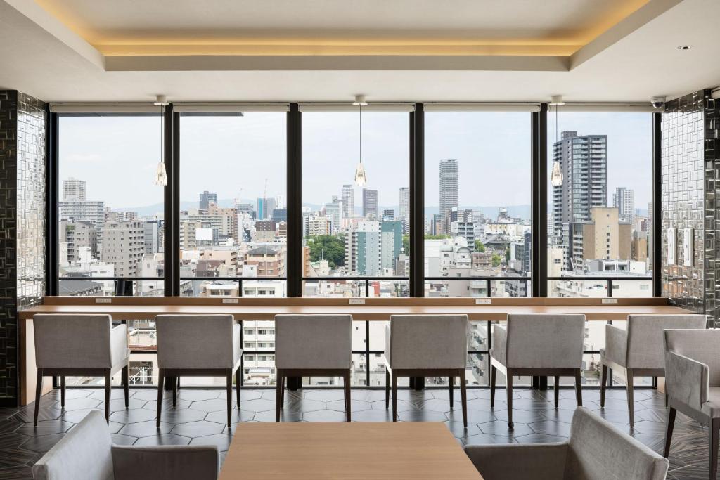 a restaurant with tables and chairs and a view of the city at the b namba-kuromon in Osaka