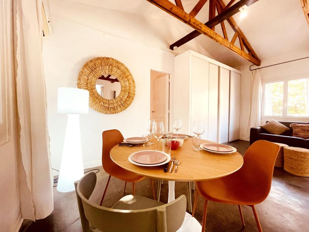 a dining room with a wooden table and chairs at Le patio, jardin privatif, tennis in Nîmes