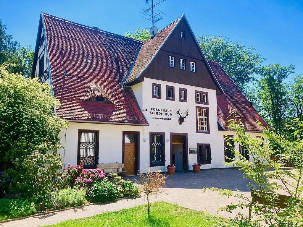 um grande edifício branco com um telhado preto em Forsthaus Siehdichum em Dammendorf