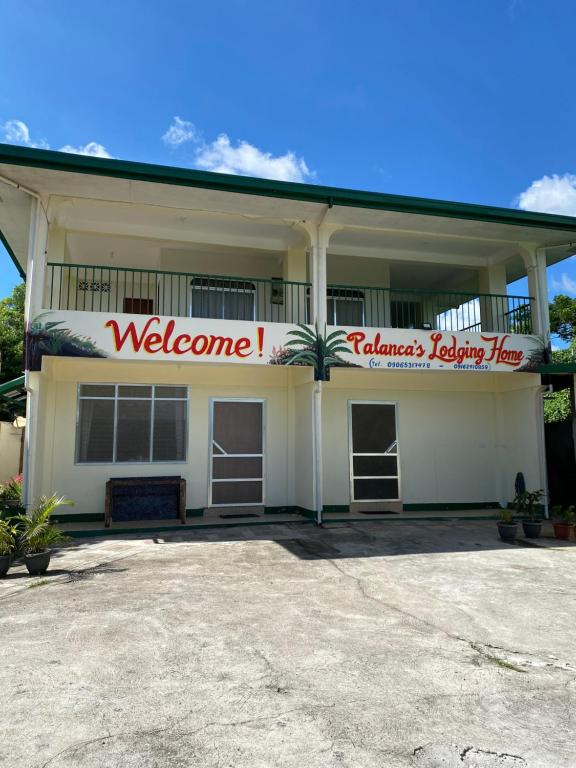 a white building with a welcome sign on it at Palanca Lodging Home in Candelaria