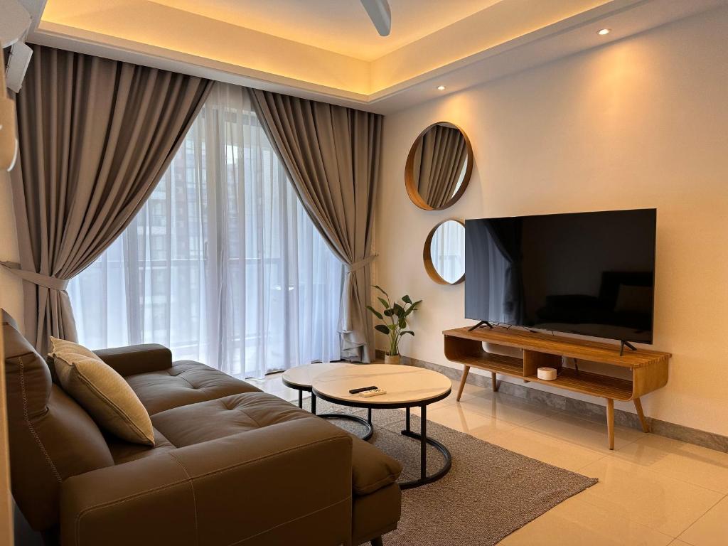 Il comprend un salon doté d'un canapé et d'une télévision à écran plat. dans l'établissement Luxury 2Bedroom R&F Princess Cove @By Hauz Cinta, à Johor Bahru