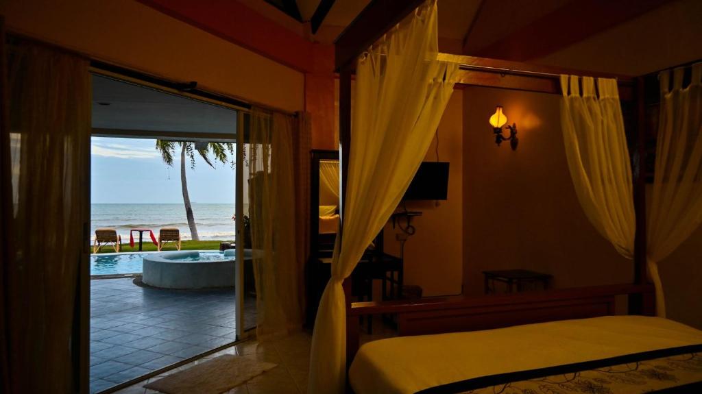 a bedroom with a bed and a view of the ocean at Crystal Paradise Resort Spa & Winery in Narra