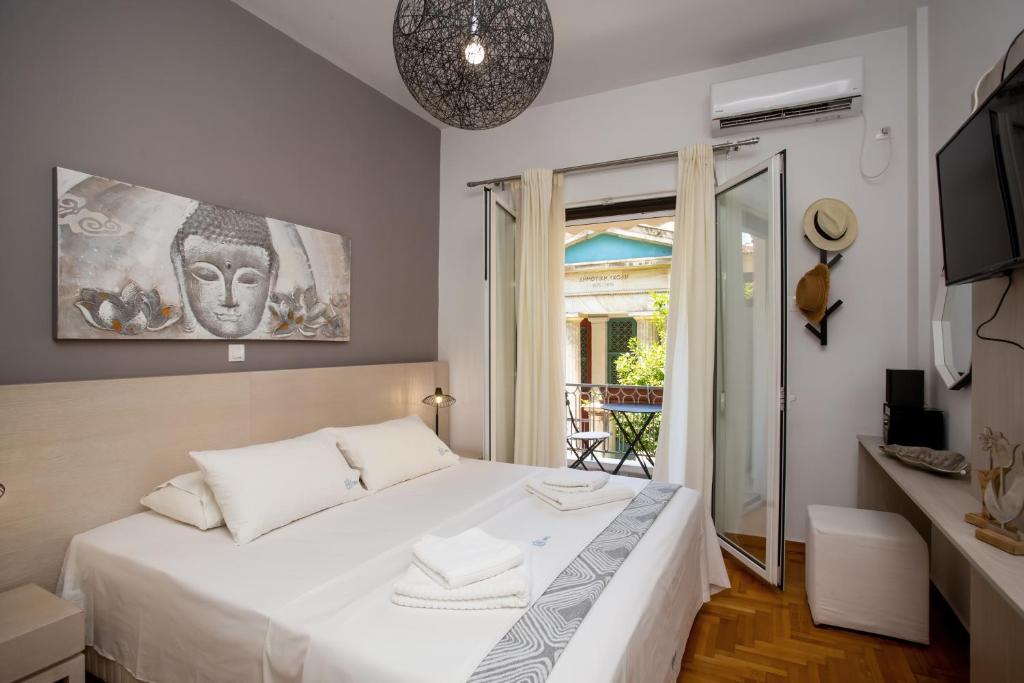 1 Schlafzimmer mit einem weißen Bett und einem Balkon in der Unterkunft Hadrian by Heloni Apartments in Athen