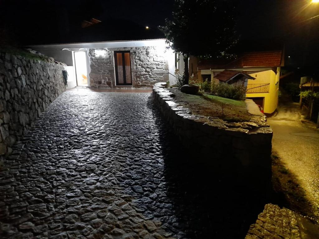 um caminho de pedra que leva a uma casa à noite em Casa Tia Vina em Arouca