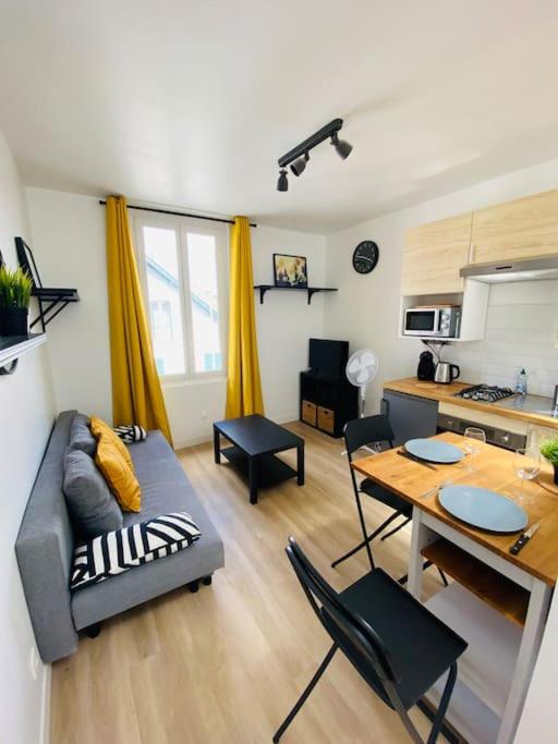 een woonkamer met een bank en een tafel bij Joli Duplex à quelques pas du centre de Bayonne in Bayonne