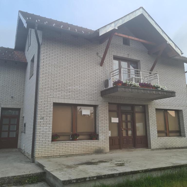 a brick house with a balcony and a window at Vila Slavonija 2 in Vrnjačka Banja