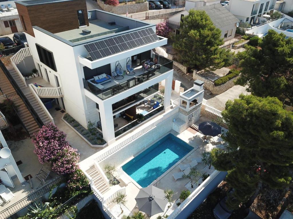 eine Luftansicht eines Hauses mit Pool in der Unterkunft Luxury Beachfront Villa Carlisa in Ciovo