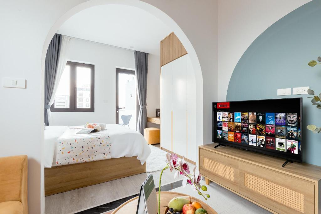 a bedroom with a bed and a flat screen tv at Crescendo Boutique Studio - STAY 24h in Hanoi
