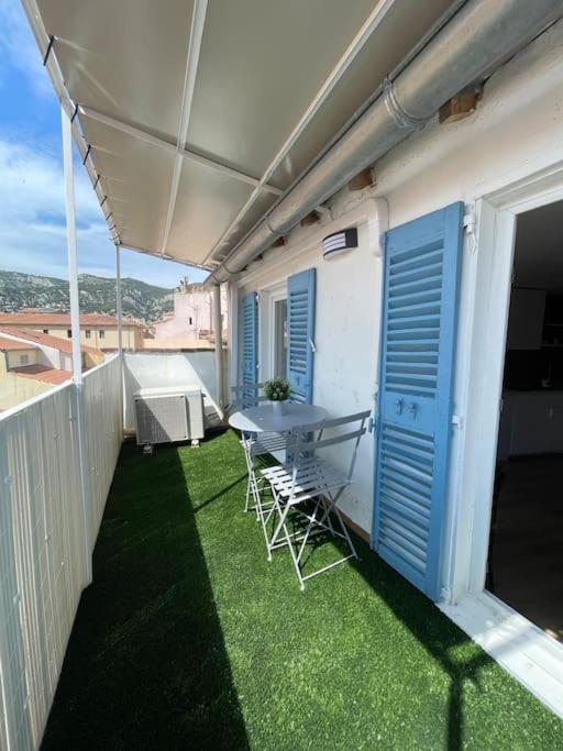 un patio avec une table et des chaises sur un balcon dans l'établissement Studio Hyper centre avec balcon WIFI et climatisation, à Toulon