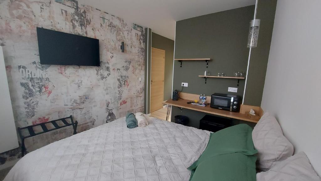 1 dormitorio con 1 cama y TV en la pared en Dandy - chambre tout confort centre-ville Nogent-le-Rotrou, en Nogent-le-Rotrou
