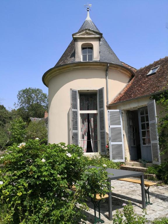 une vieille maison avec une tour en haut dans l'établissement Gite La Tourelle Château de Montchevreau, à Cosne Cours sur Loire