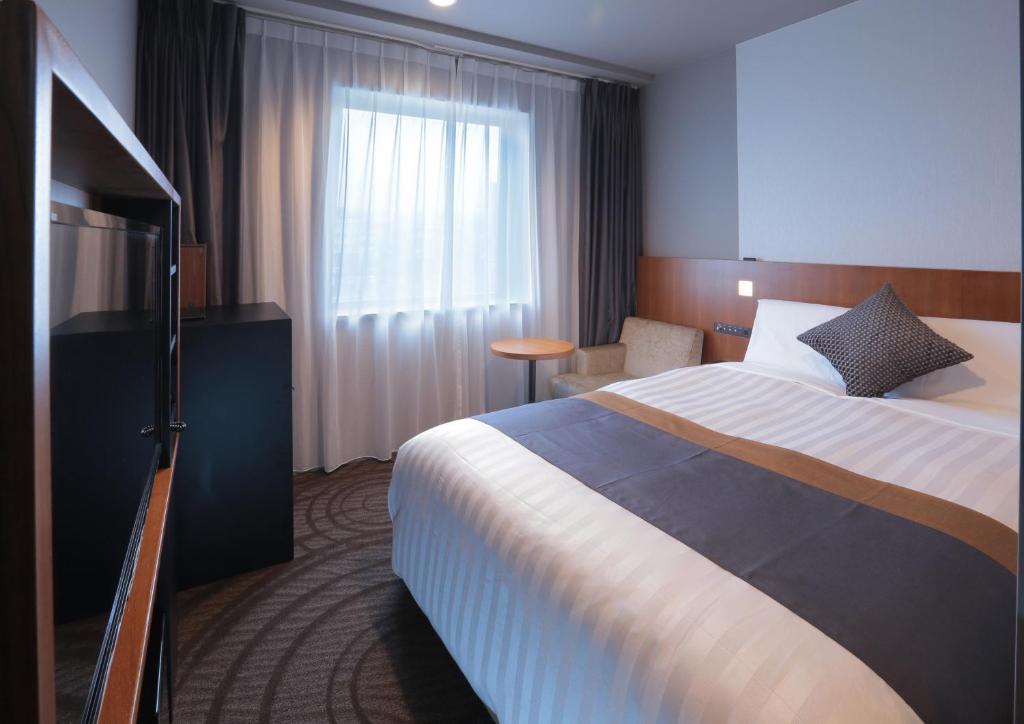 Postel nebo postele na pokoji v ubytování Kisarazu Washington Hotel