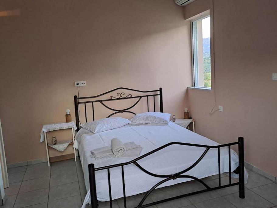 a bedroom with a bed with white sheets and a window at Fully equipped apartment in Apokoronas in Nípos