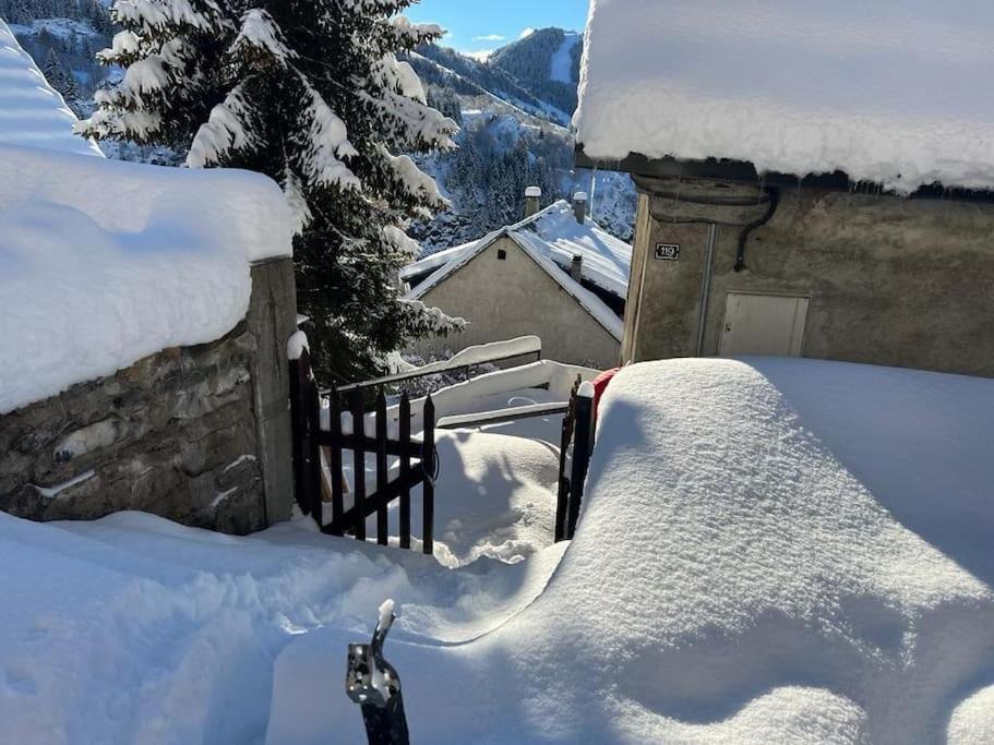 een tuin bedekt met sneeuw naast een huis bij Les Astrances, logement dans une maison de village in Huez