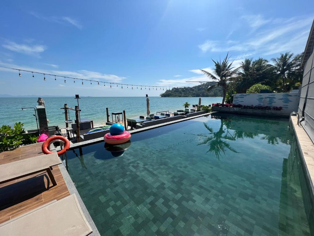 a swimming pool with a view of the ocean at The Nchantra Beachfront Resort in Phuket