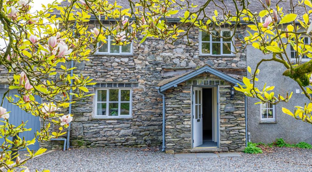 a stone house with a blue door and windows at Grassholme Cottage in Far Sawrey