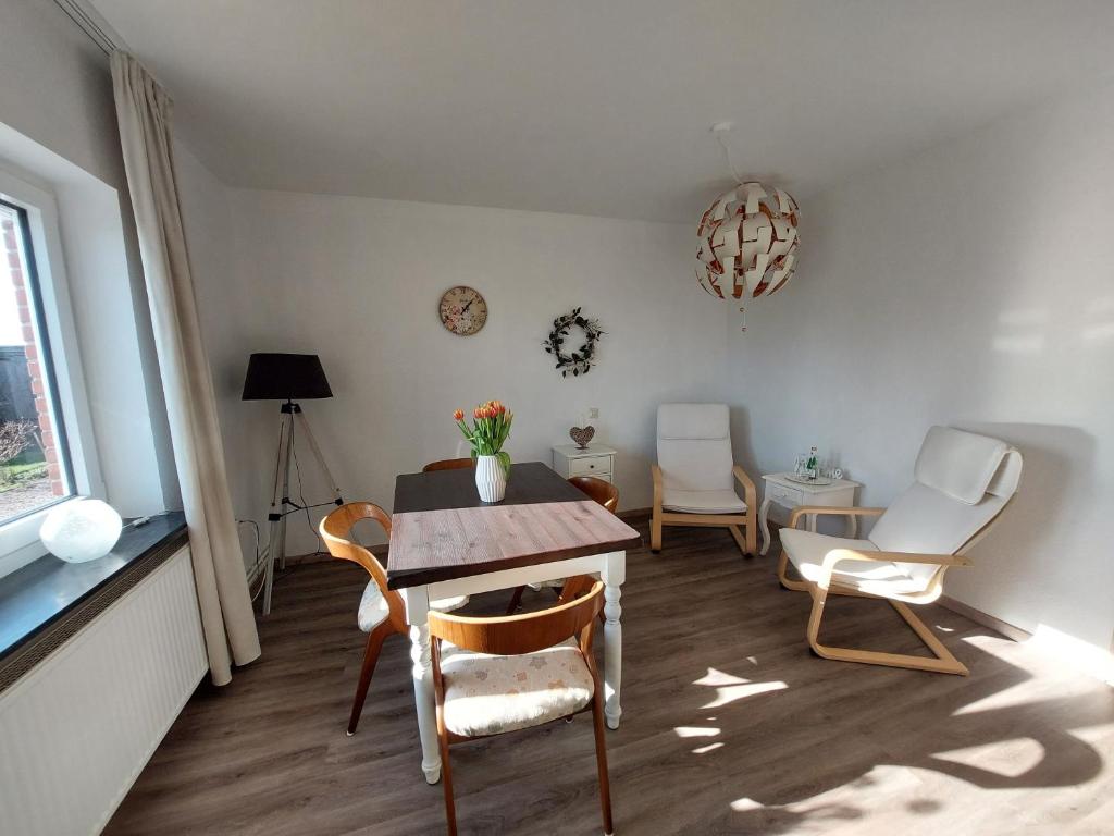 Rabenholz的住宿－Ferienwohnung Asmuss in Rabenholz，客厅配有桌椅和窗户。