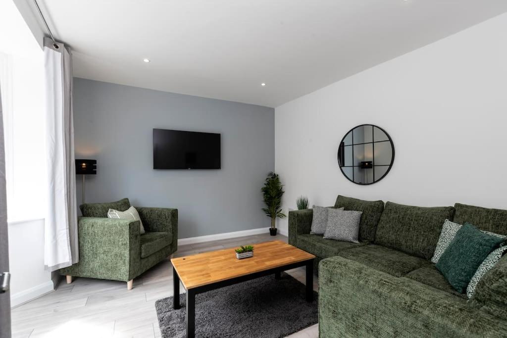a living room with a couch and two chairs and a table at Stunning newly decorated House - TV in each Bedroom in Darlington