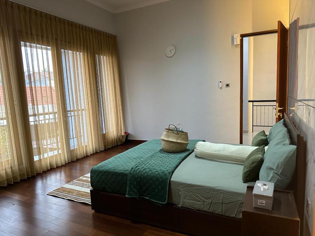 a bedroom with a bed with a basket on it at Villa Magnifica by REQhome in Ciater-hilir