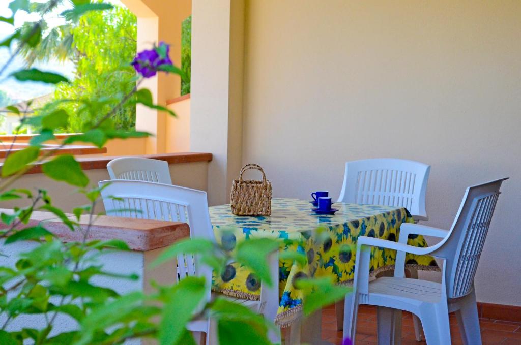 een tafel met vier stoelen en een tafel met een mand erop bij Appartamenti Casa Dini in Marina di Campo