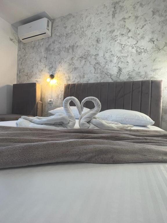 a bedroom with a bed with two white swans on it at Ana Boutique in Constanţa
