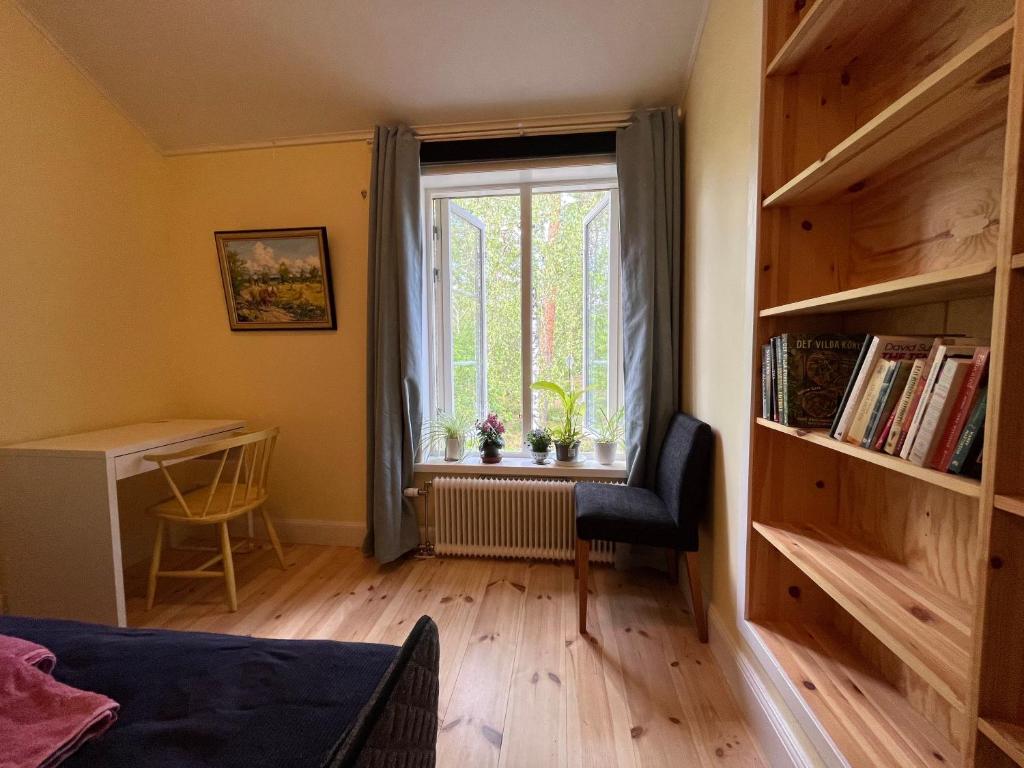 - une chambre avec une fenêtre, une chaise et un bureau dans l'établissement Bed&Breakfast in nature 12 min from city free bikes, à Stockholm