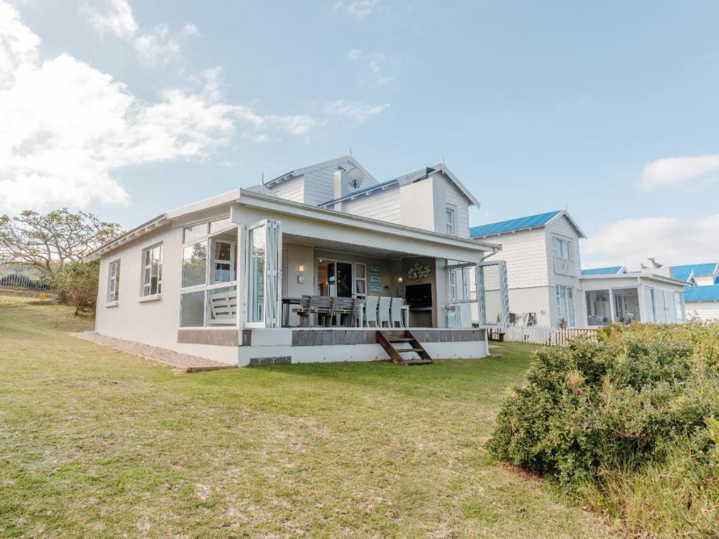 a white house with a yard at Pinnacle Point Lodge 21 in Mossel Bay