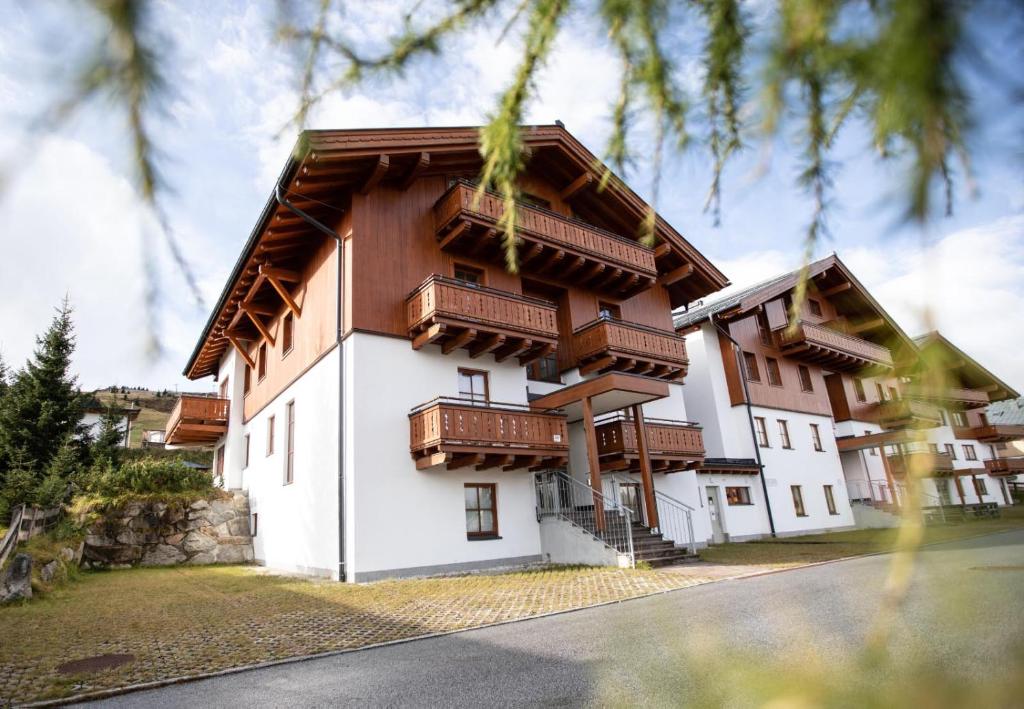 Un edificio con balcones de madera en los laterales. en Ferienwohnung Hochkrimml 19 __1-4, en Königsleiten