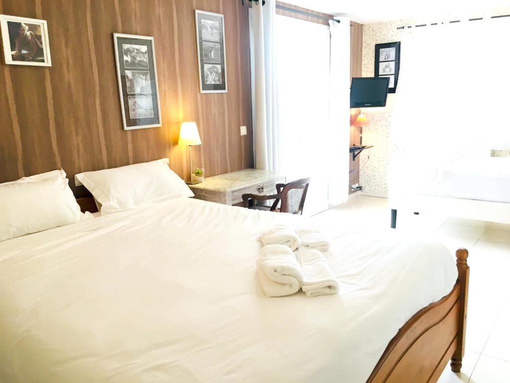 a bedroom with a large white bed with towels on it at Maison charmante à Saint-Géry avec piscine partagée in Saint-Géry