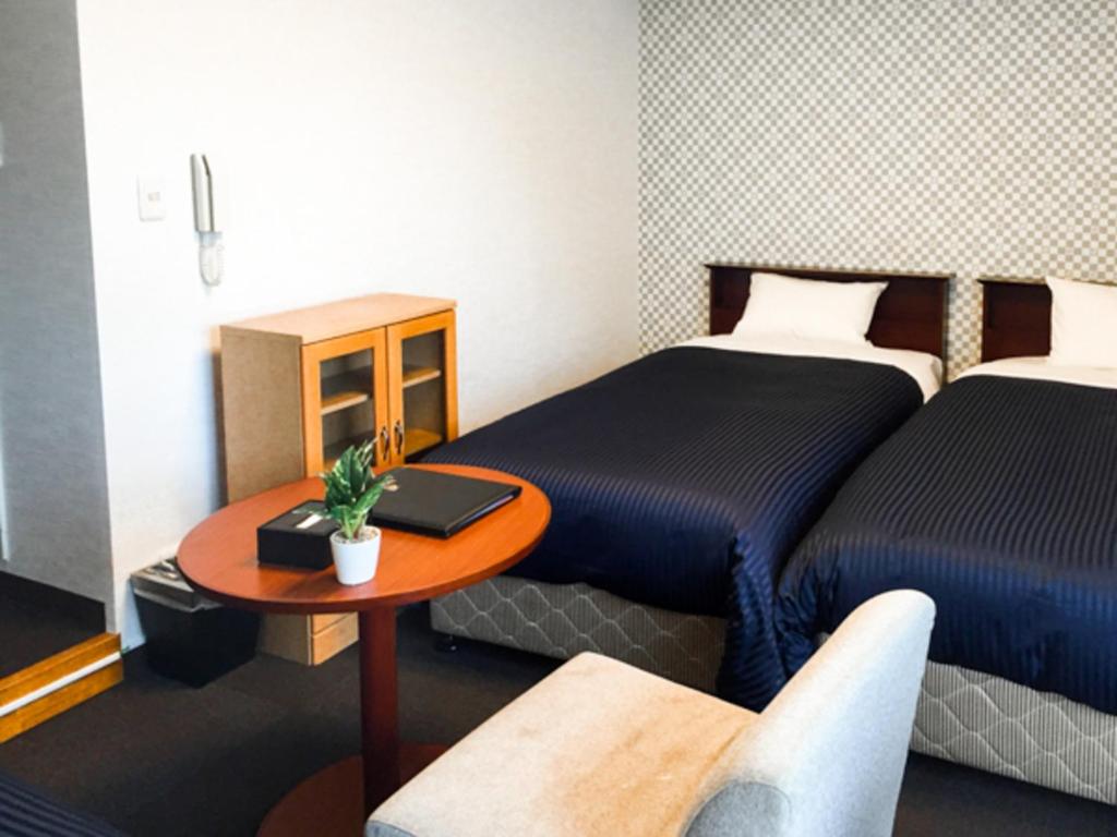 Postel nebo postele na pokoji v ubytování HOTEL LiVEMAX BUDGET Fuchu