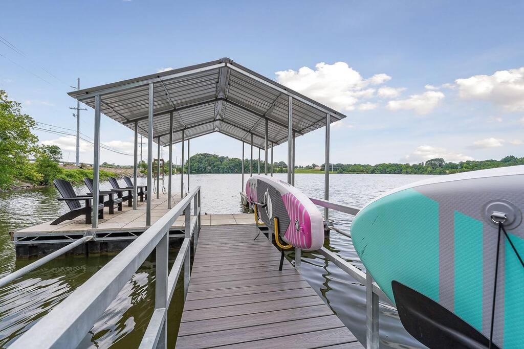 a dock with benches and a boat on the water at Lake Home, Dock, Fire Pit, Hot Tub, Game Room, Etc in Winchester