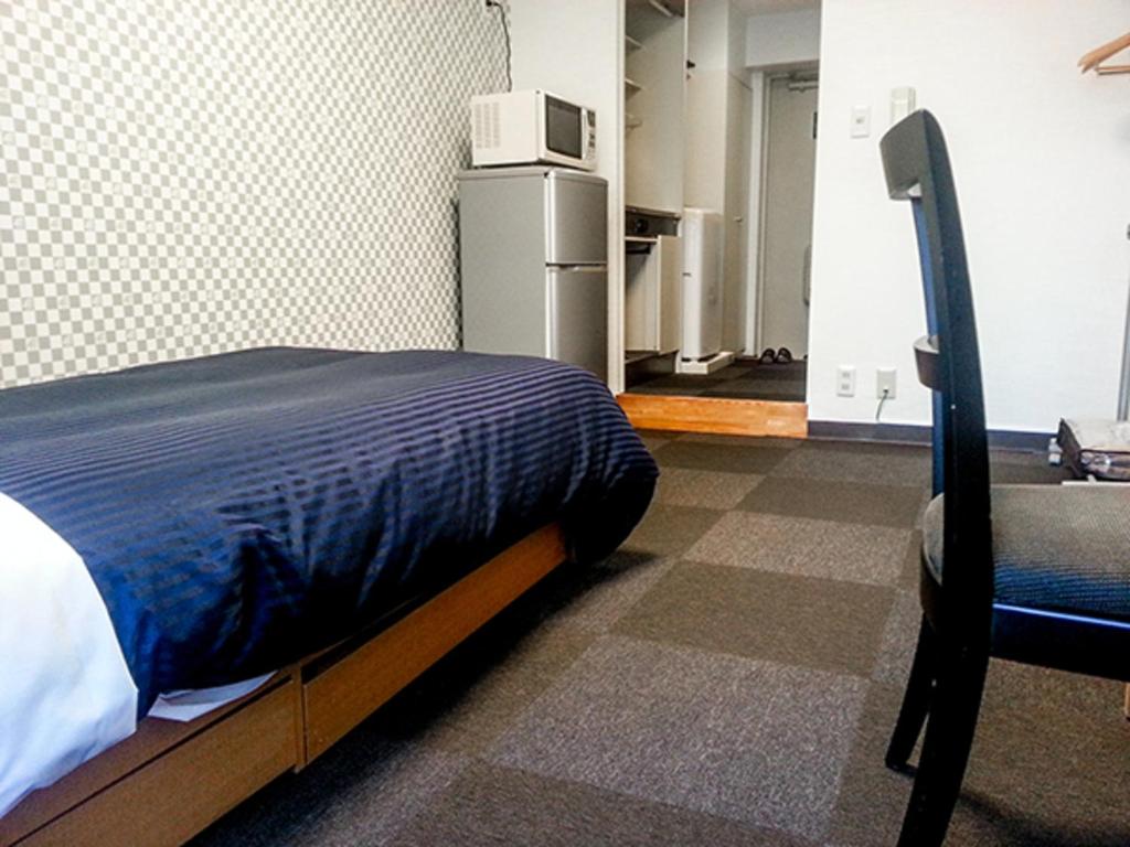Postel nebo postele na pokoji v ubytování HOTEL LiVEMAX BUDGET Fuchu