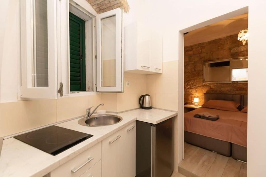eine Küche mit einem Waschbecken und ein Bett in einem Zimmer in der Unterkunft ApartmentTHE old centar of Split in Split
