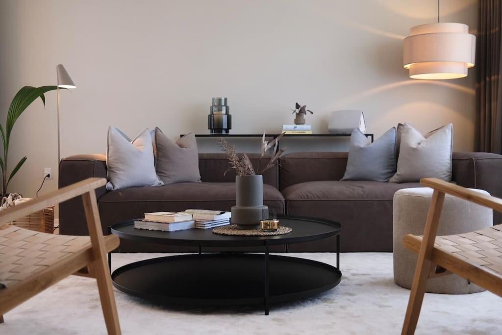 - un salon avec un canapé brun et une table dans l'établissement Lovely villa at the foot of the Funen Alps, à Fåborg