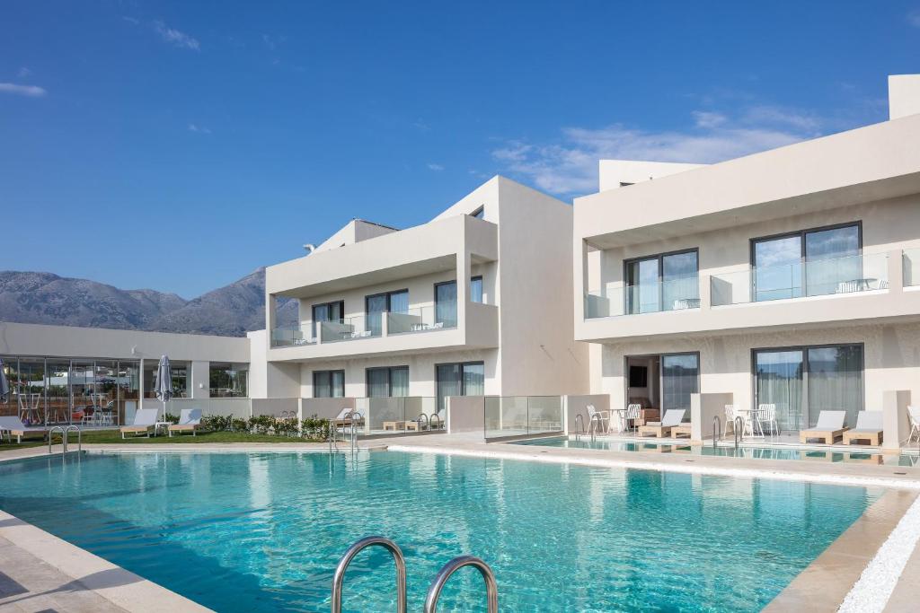 a villa with a swimming pool and mountains in the background at Nima Boutique Hotel in Kavros