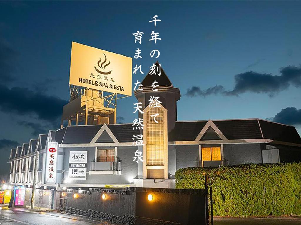 a building with a sign on top of it at night at HOTEL&SPA SIESTA ( Adult Only) in Ikuma