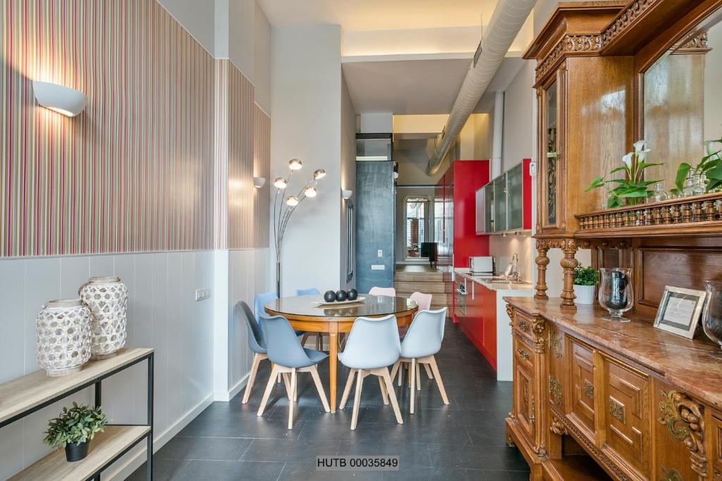 a kitchen with a table and chairs and red cabinets at Alcam Les Corts in Barcelona