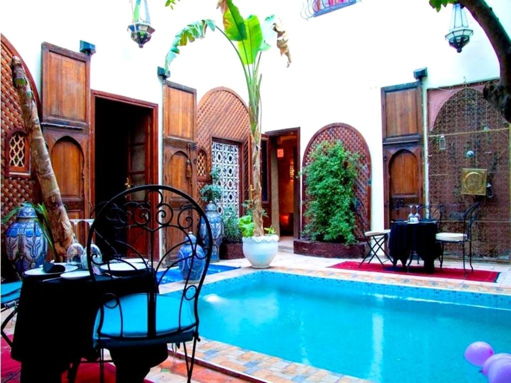 マラケシュにあるExceptional Villa in Marrakech with Private Poolのテーブルと椅子が隣接するスイミングプールを利用できます。