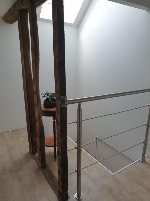 a glass and metal railing in a room with a table at La petite Longère de Vin'Ay in Vinay