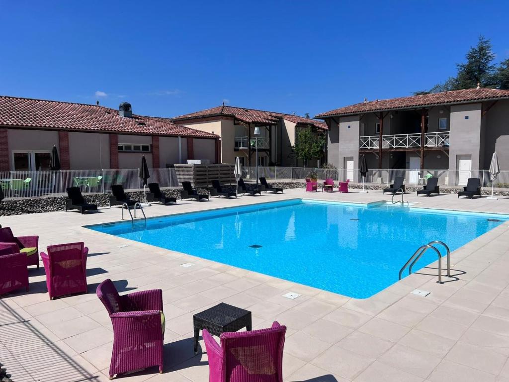 uma grande piscina com cadeiras e um edifício em Les bords de l'Aveyron em Nègrepelisse