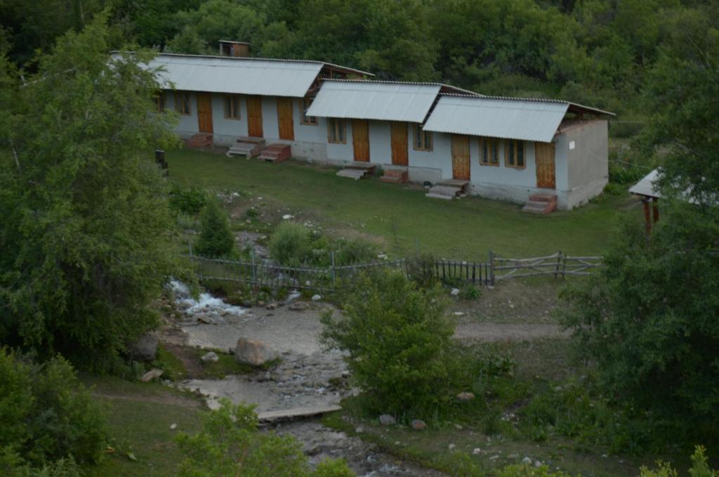 um par de edifícios ao lado de um rio em Ak-Kaiyn Summer Rest Place em Kaindy