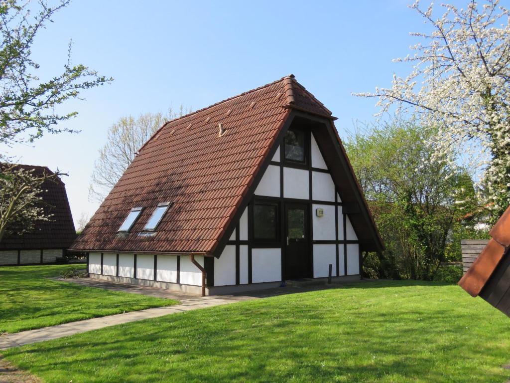 una casa con tetto piastrellato su un prato di Ferienhaus Lederstrumpf im Feriend a Bachenbrock