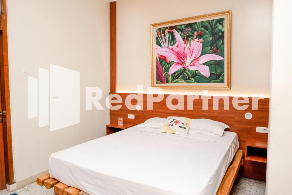 Postel nebo postele na pokoji v ubytování Mango House Semarang RedPartner