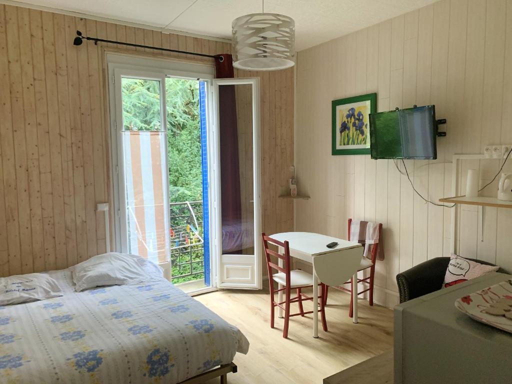 um quarto com uma cama, uma mesa e uma janela em Studio avec wifi a Neris les Bains em Néris-les-Bains